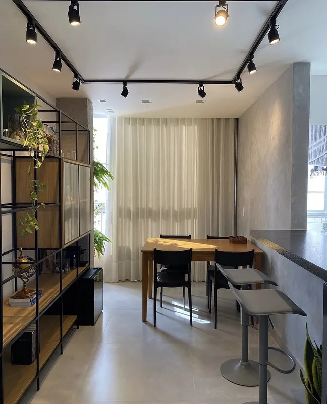 Sala de jantar reformada pela Si.Go com iluminação em trilho e estante industrial